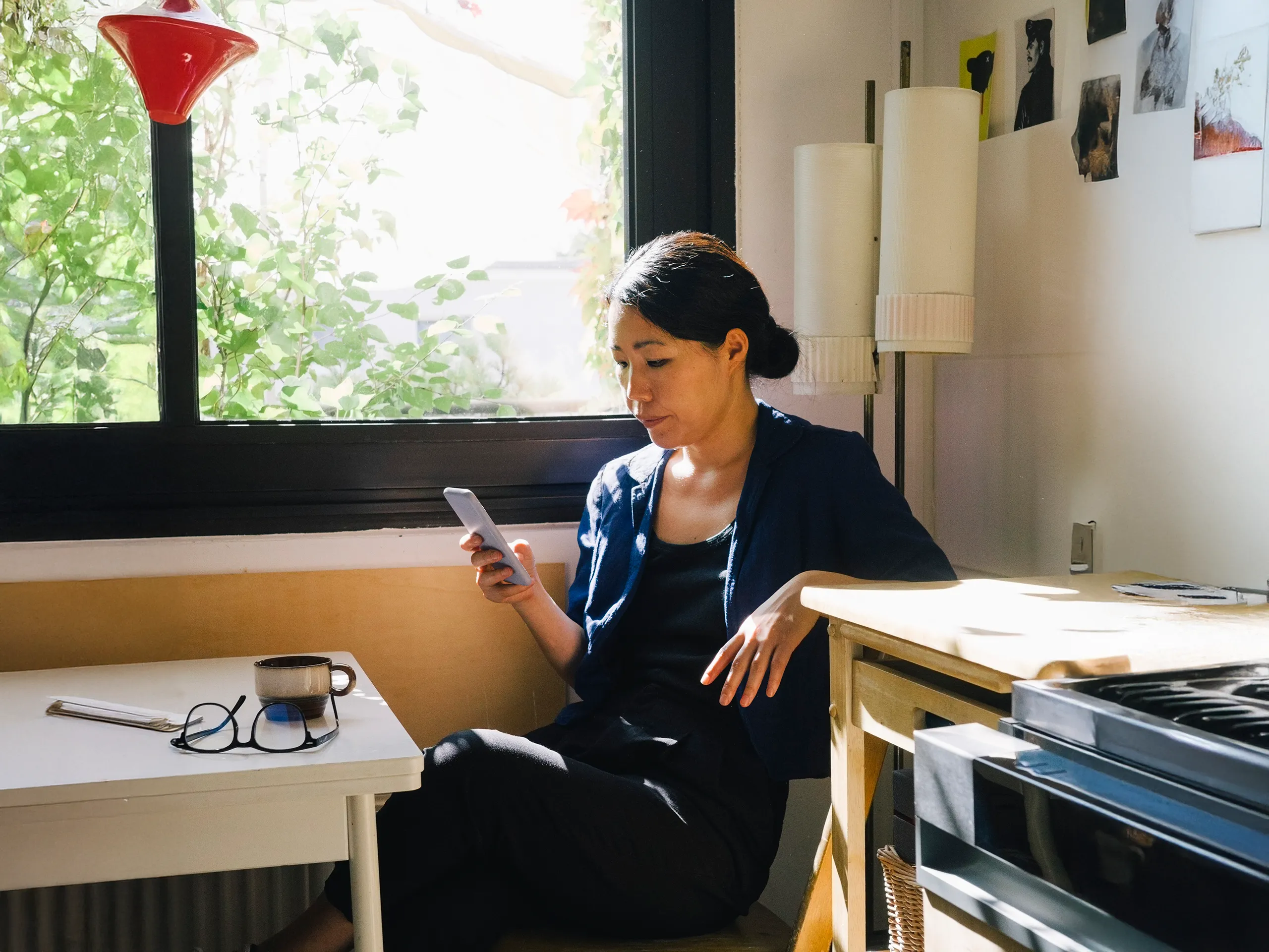 Frau sitzt entspannt in der Sonne und schaut auf ihr Smartphone.